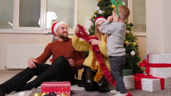 Happy Family Having Fun and Playing Together Near Christmas Tree