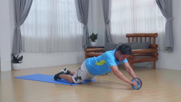 Man Doing Ab Wheel Rollout Exercise At Home