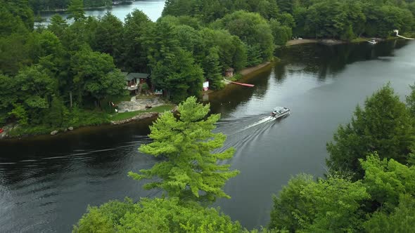 Aerial view of boat driving down Muskoka river in cottage country