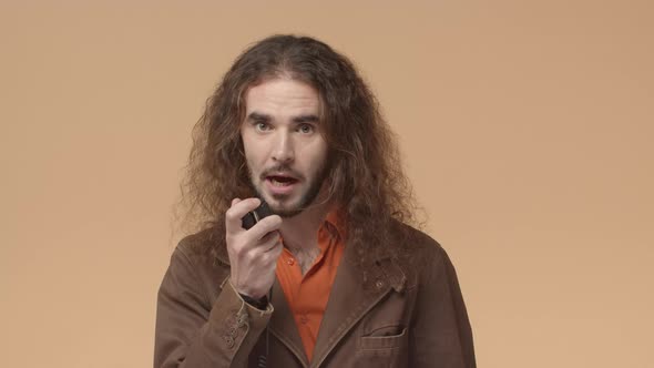 Hipster Guy with Beard and Long Curly Hair Asking Question Via Transmitter Talking to Disptetcher