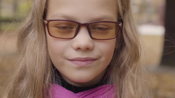 Close-up Portrait of a Shy Caucasian Teenage Girl Looking at the Camera and Smiling