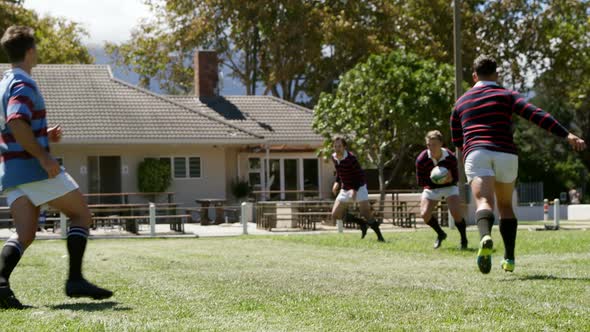 Rugby players try to defend oval ball from other team