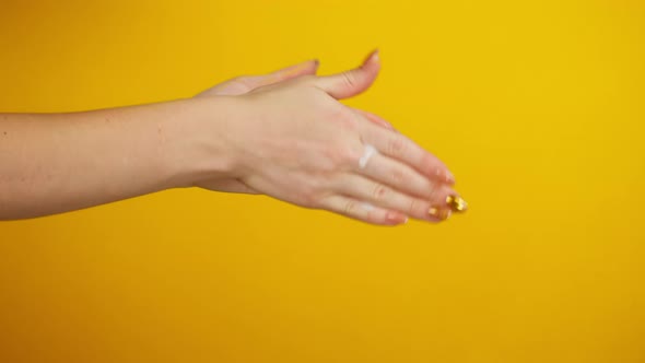 Washing Female Hands on Yellow Background Using Liquid Soap or Foam