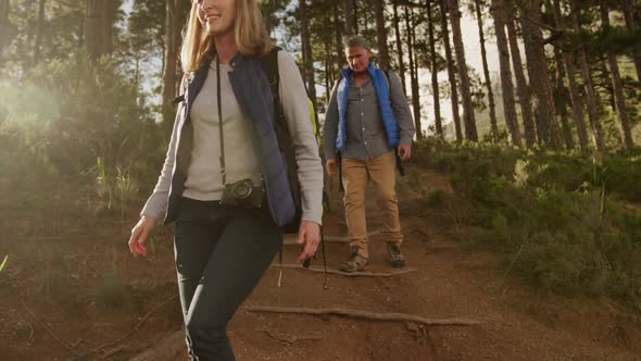 Active senior couple hiking in forest