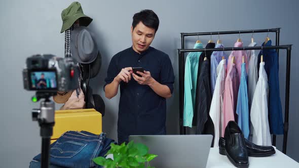 man selling clothes and accessories online by using smartphone and camera live streaming