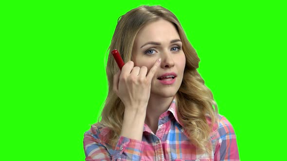 Charming Girl Puts on Makeup on the Green Screen