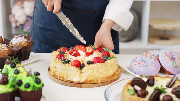 Female Confectioner Hands Cutting Appetizing Fresh Cake Using Knife