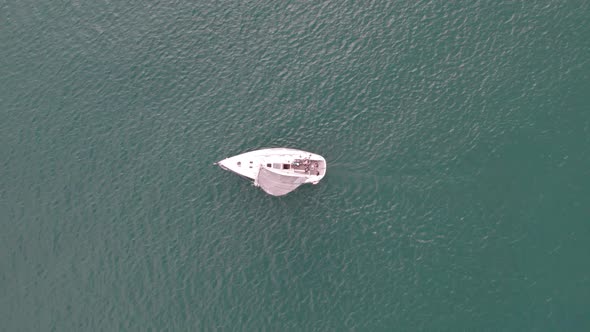 Top down view of sailing yacht with white sail