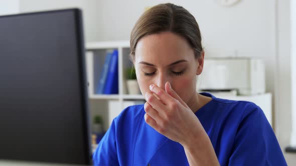 Tired Doctor with Computer Working at Hospital