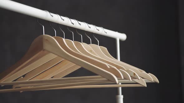 Wooden Hanger on Dark Background. Number of Empty Hangers