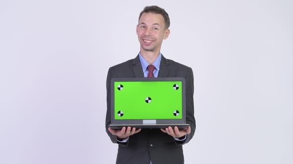 Studio Shot of Happy Businessman Showing Laptop