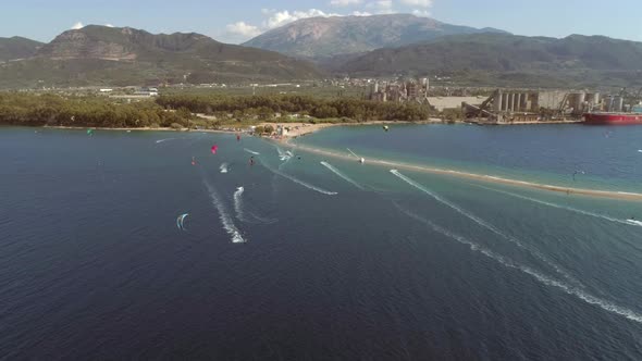 Aerial view faraway of group kitesurfing at Gulf of Patras, Greece.