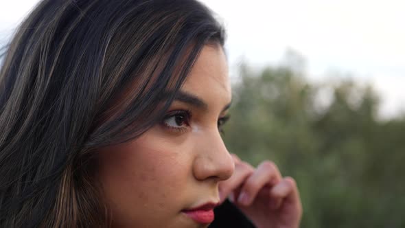 Adult hispanic woman putting on a reusable cloth respiratory face mask to prevent infection from the