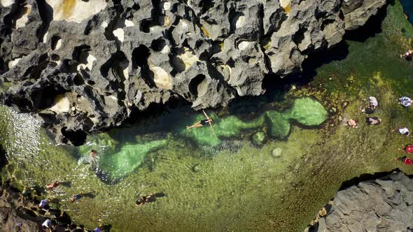 Young Beautiful Woman Swims in a Natural Pool Angel's Billabong at Broken Beach in Nusa Penida