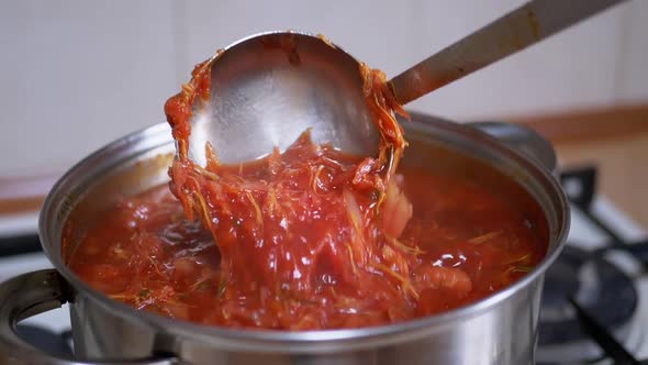 Preparing Rich Thick Red Borscht From Meat Beet in a Saucepan in Home Kitchen