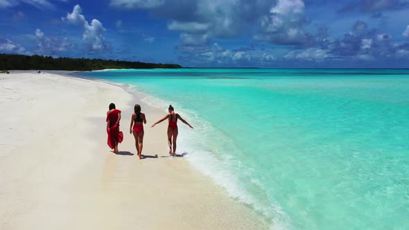 Pretty smiling girls travelling having fun at the beach on summer white sand and blue background 4K