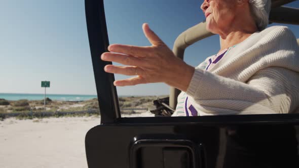 Senior woman with a car at the beach