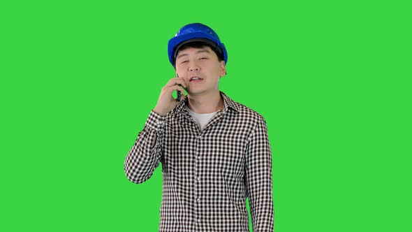 Asian Construction Worker Making a Call on a Green Screen Chroma Key alt