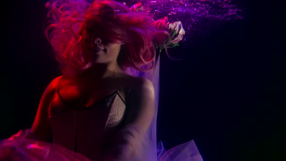 Portrait of a Woman with Long Red Hair and a Corset in Dark Water. She Hovers and Moves Her Arms