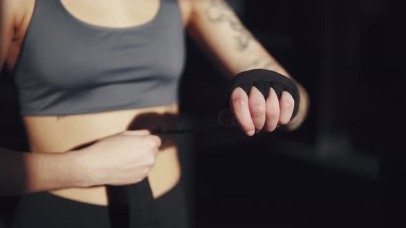 Athlete Pulls on His Wrists Protective Bandages Before Boxing Training