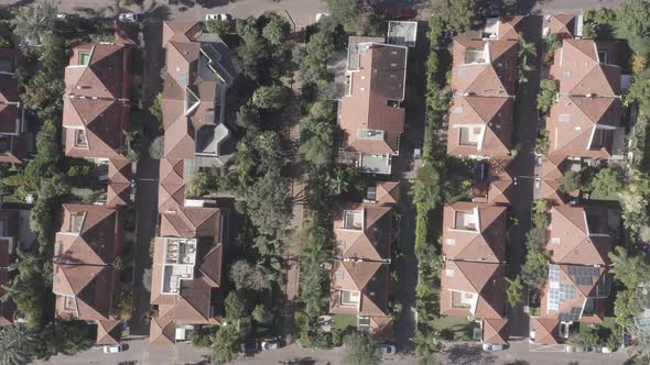 Classic Suburban houses with red rooftops and green trees.