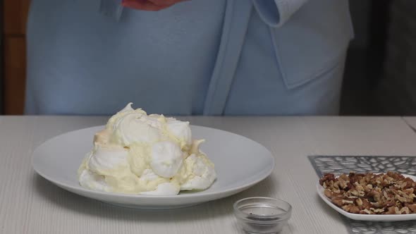 A Woman Prepares A Cake Count Ruins From Meringue. Decorate The Cake With Liquid Chocolate.