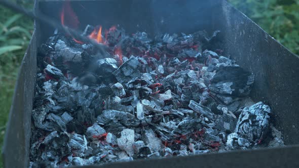 Coals burning in grill. Grill with hot coals. Smoke from a fire.