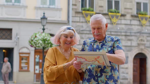 Senior Grandmother and Grandfather Tourists Looking for a Place to Go in New City Using Paper Map