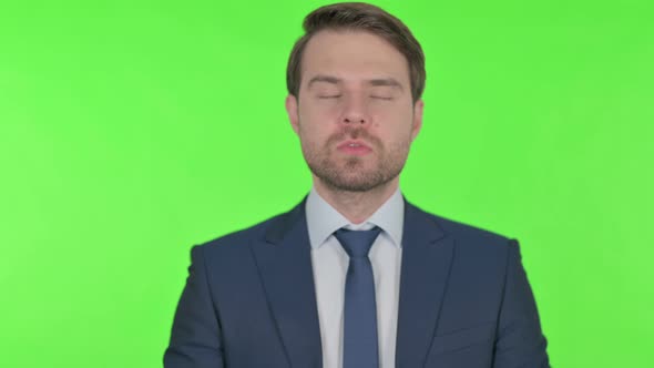 Disappointed Young Businessman Reacting Loss on Green Background