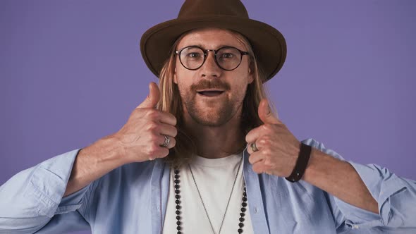 Bearded Guy in Blue Shirt Glasses Hat and Jewelry