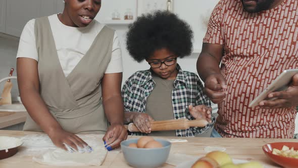 African American Boy Making Apple Pie with Parents at Home