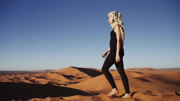 Tourist Walking Barefoot Over Sand Dune In Desert