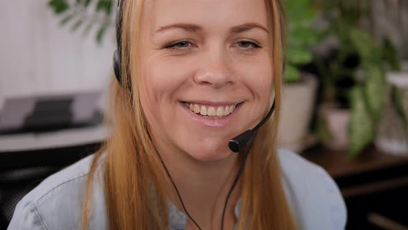 Smiling Woman Working As Customer Support Operator with Headset in a Call Center