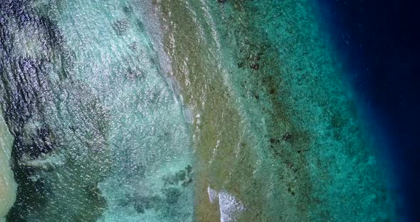 Wide angle aerial travel shot of a white sandy paradise beach and aqua turquoise water background 