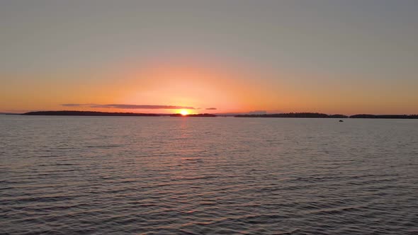 Drone flying fast over water and sunset