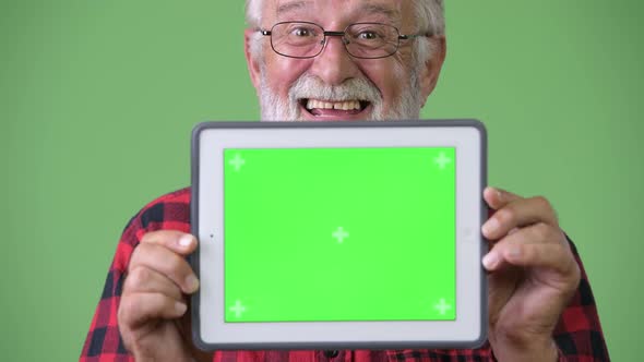 Handsome Senior Bearded Man Against Green Background