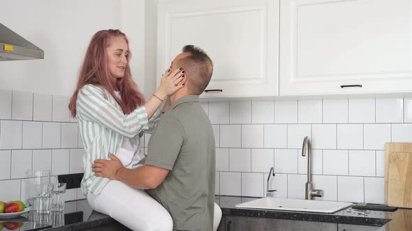 Couple Hugging Kissing in Modern Cozy Light White Kitchen at Home Breakfast