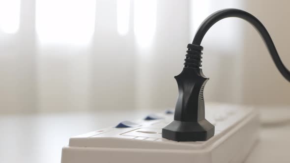 Close up Male hand unplugs in a power cord on the table