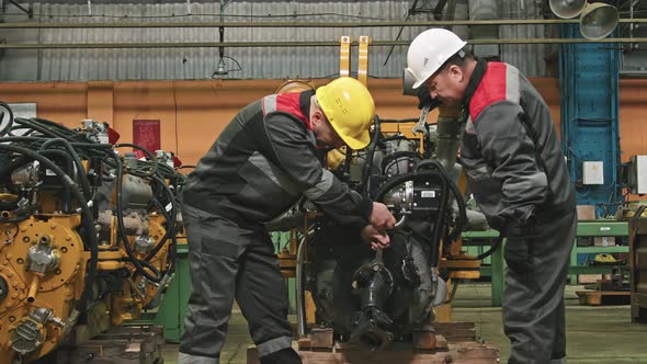 Plant Workers Fixing Machinery Equipment