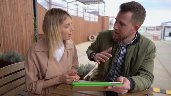 Man and Woman Talking Over Gadget Outdoor