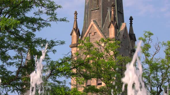 Church steeple with fountain in foreground.