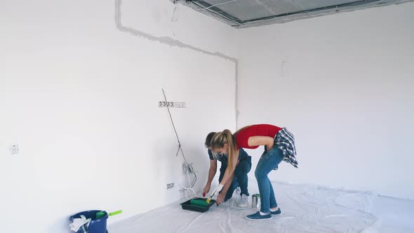 Happy Man with Pretty Wife Begins Painting White Room Wall