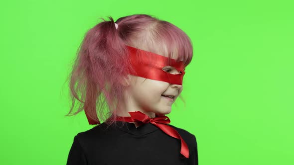 Funny Child Girl in Costume and Mask Plays Super Hero. National Superhero Day