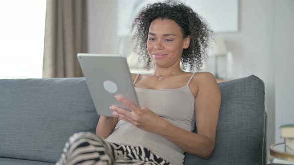 Serious African Woman Using Tablet at Home