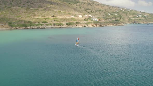 Aerial view of man doing windsurfing at the sea in Greece.