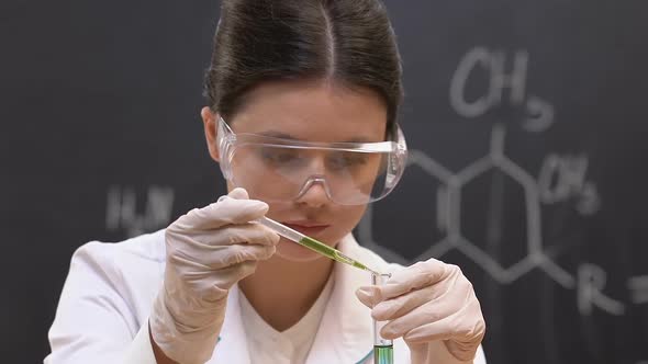 Female Student Adding Liquid Into Test Tube, Chemical Laboratory Work, Reaction