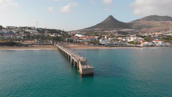 Drone flies around a walkway leading out from the island of Porto Santo.