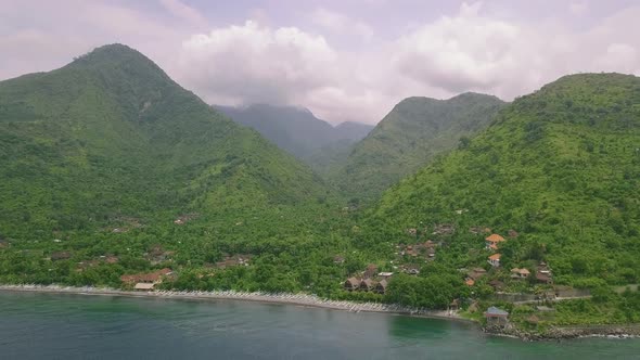 Scenic View of Village in the Mountains Covered with Lush Greenery Near the Sea