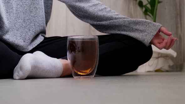 Young Millennial Blonde Woman Drinking Tea and Doing Yoga Exercise Stretching Fitness at Balcony