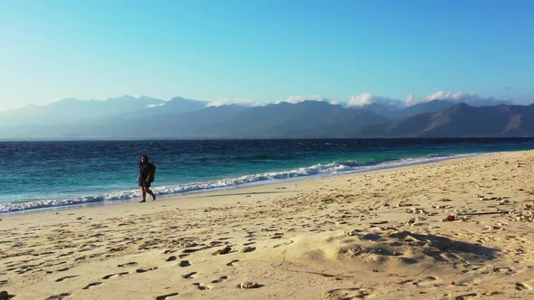 Single female sunbathing on idyllic sea view beach lifestyle by transparent ocean and clean sandy ba